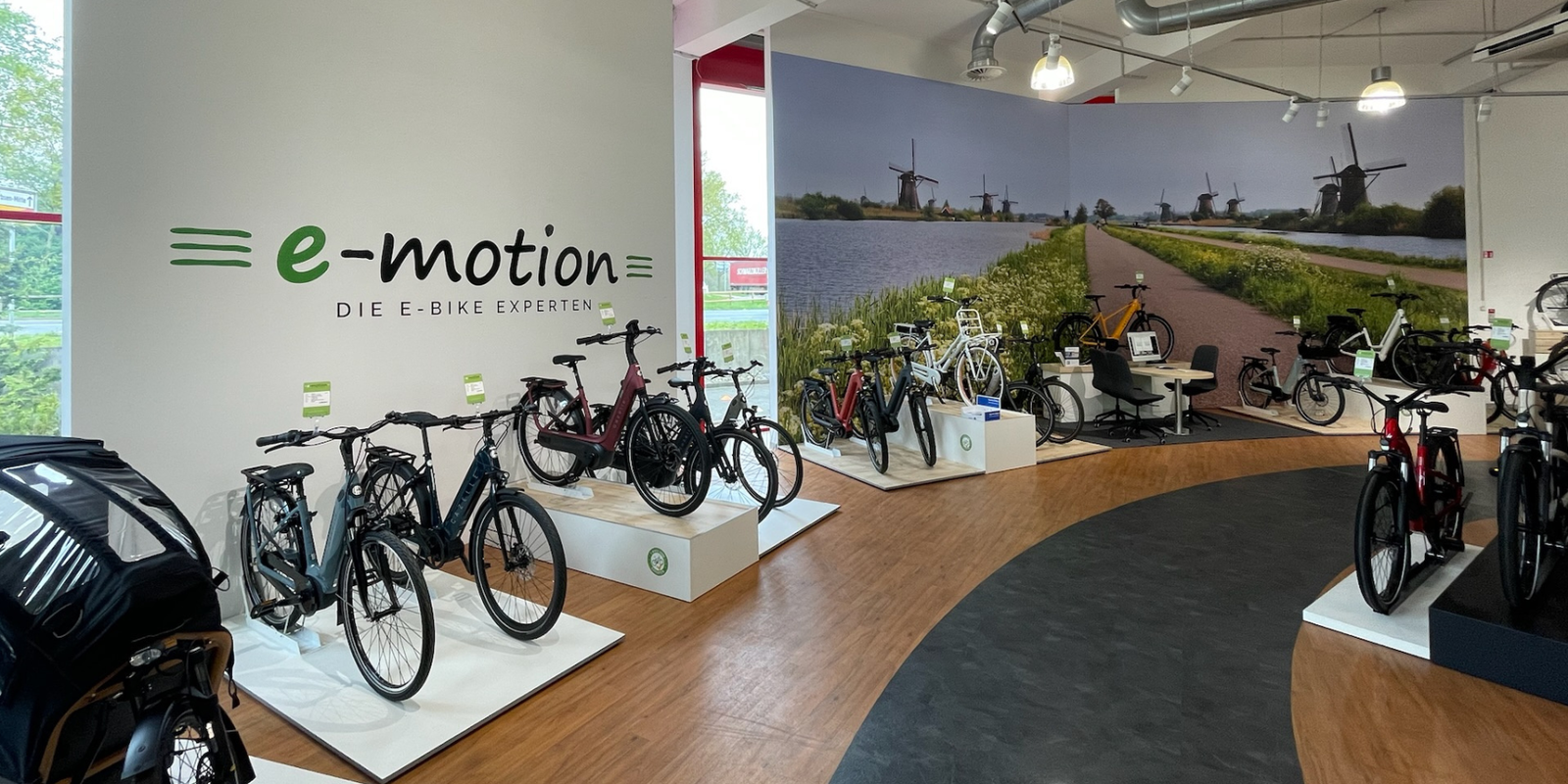 Neuer Verkaufsraum der E-Bike-Experten e-motion in Hannover-Garbsen mit beleuchteten großformatigen Imagebildern und einer Teststrecke für Fahrräder nach der Umgestaltung durch Schemberg Ladenbau