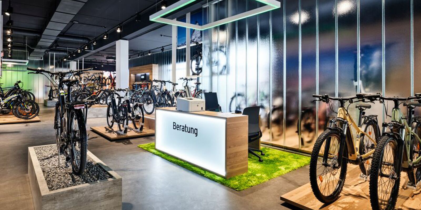 Neuer Verkaufsraum von eBiker in Laufenburg mit beleuchteten großformatigen Imagebildern und Beratungsecken nach der Umgestaltung durch Schemberg Ladenbau