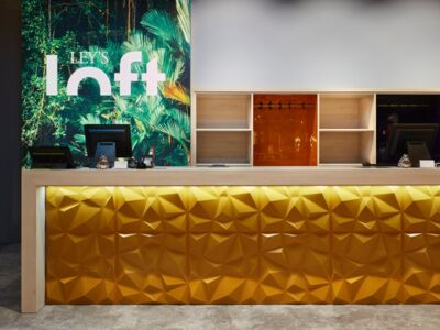 Leys Loft Verkaufstresen mit goldener Front und hellem Eichendekor in Frechen für junge Mode von Schemberg Ladenbau